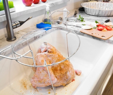 Uncooked Thanksgiving turkey is sitting in the kitchen sink.